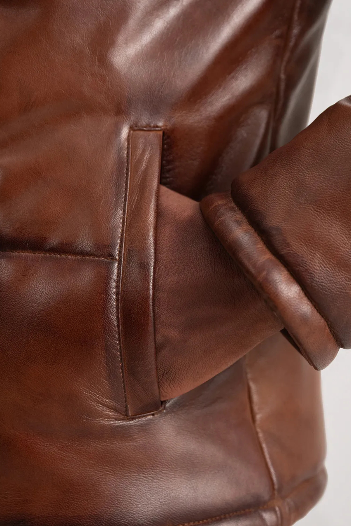 Close-up of a brown leather jacket with a pocket