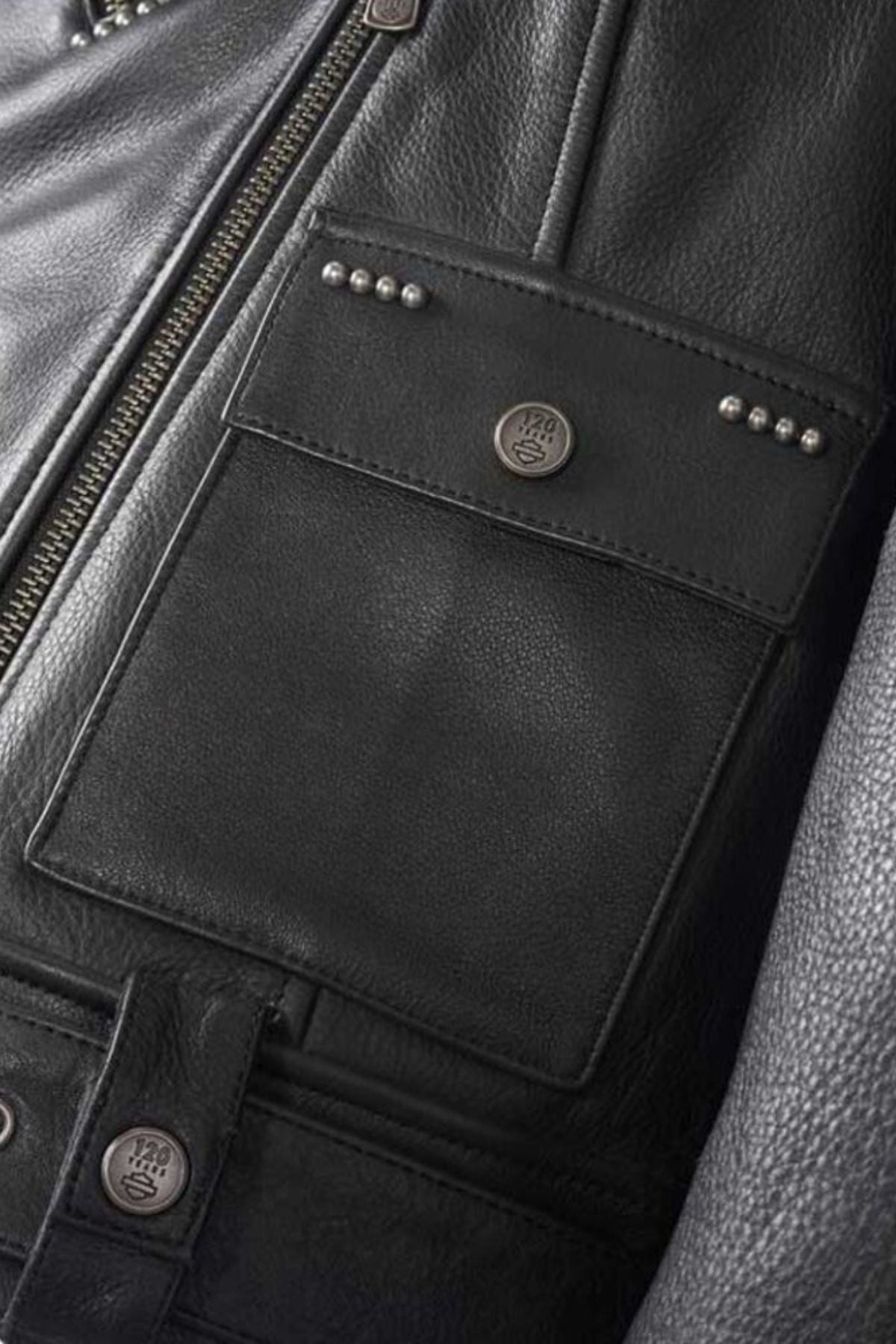 Close-up of a black leather jacket with studded details and buttons.