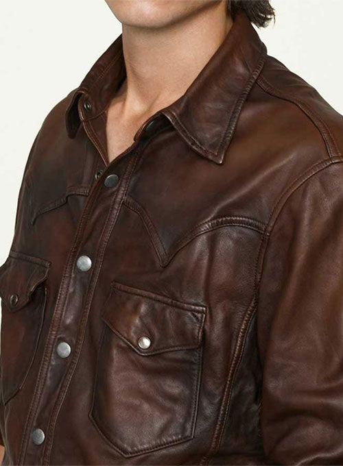 "Close-up of the distressed brown leather and classic Western yoke design on a men's shirt"