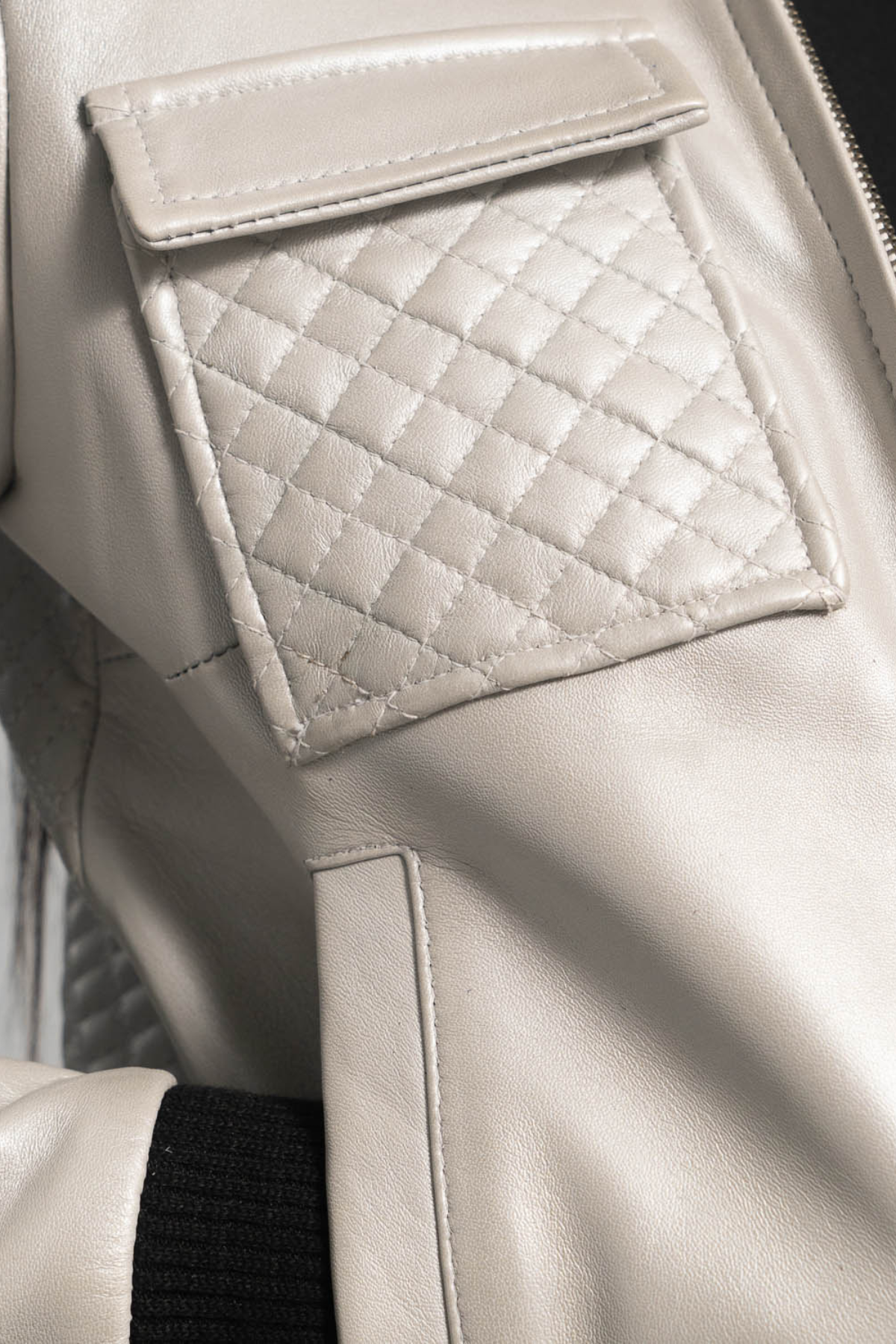 Close-up of a quilted leather pocket on a beige leather jacket.