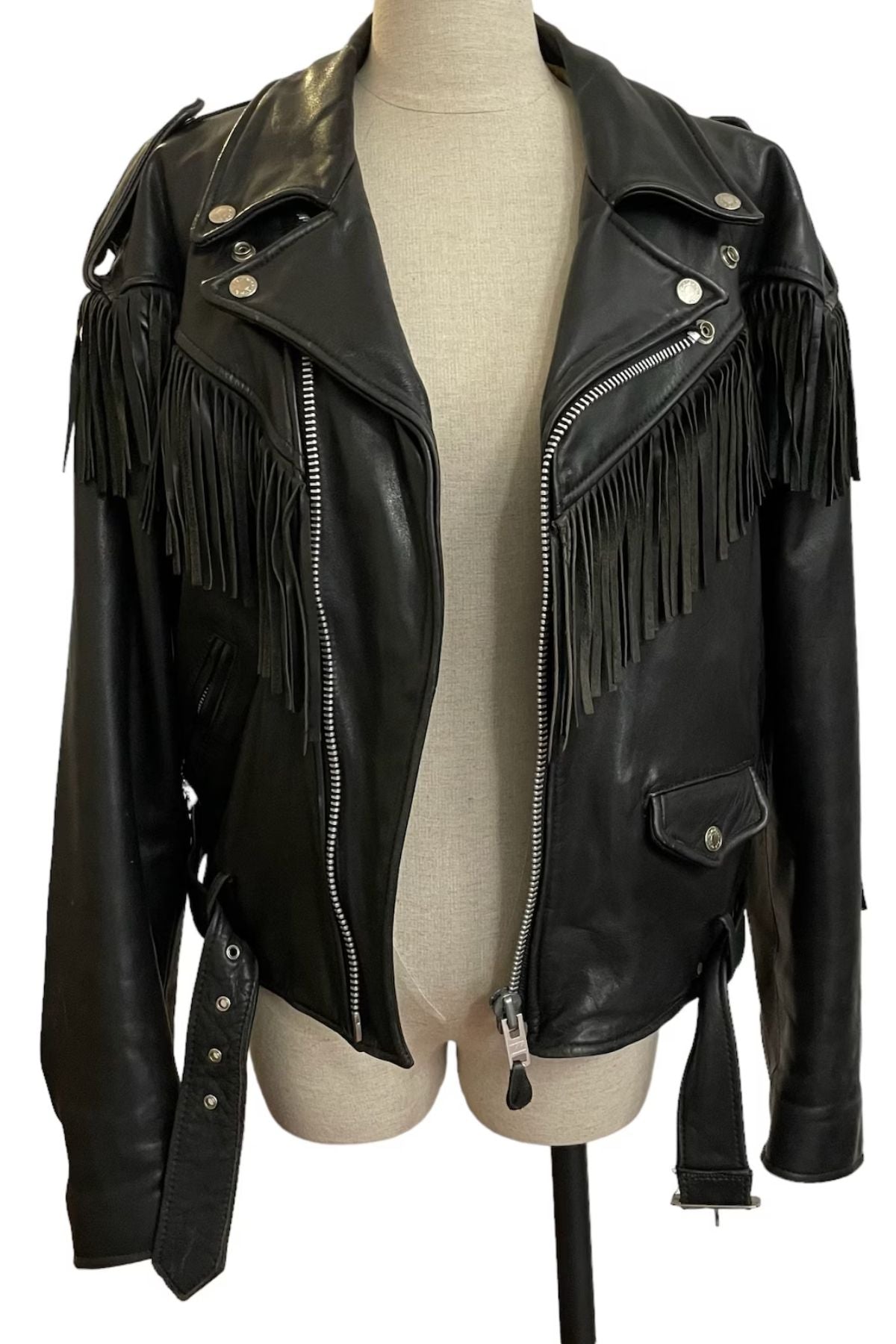 Black leather jacket with fringe details on a mannequin 
