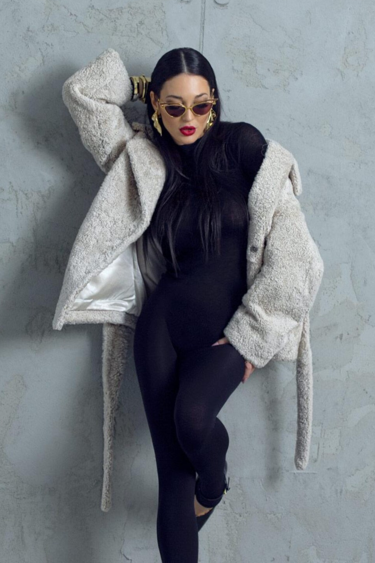 Person wearing a black outfit with a gray textured coat 